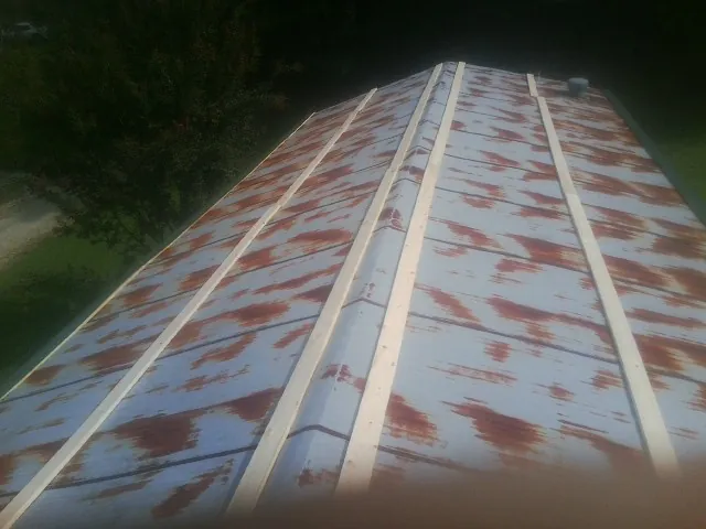 Rusted metal roof panels with new wood purlins before replacement — Storm Damage Roof Repair in Gray Summit by Roofing Brothers